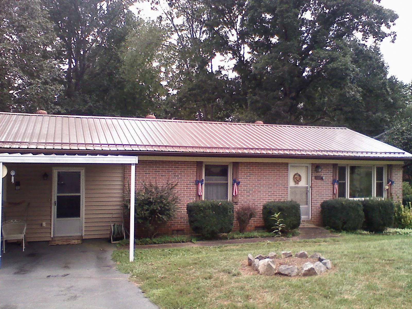 Bronze metal roof and carport on a brick ranch home — Roof Repair work by our crew in Bolckow